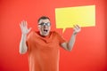 Happy smiling man holding yellow bubble speech, looking at camera over red background Royalty Free Stock Photo