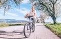 Happy smiling man riding a bicycle on the country road under blossom trees. Spring is comming concept image