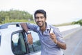 Happy smiling man standing near his new car showing credit card Royalty Free Stock Photo