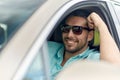 Happy smiling man in sunglasses driving car