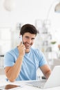 Happy smiling man talking over phone, working at laptop discusses ideas with the customer