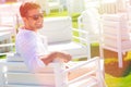 Happy and smiling man on vacation sitting in a beach resort with green lawn. With sunglasses. Intense daylight, the young man Royalty Free Stock Photo