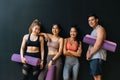 Happy smiling man and women having fun talking in gym. Group of young people relaxing in gym after workout training. Royalty Free Stock Photo