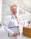 Happy smiling mature doctor writing on clipboard Royalty Free Stock Photo