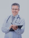 Happy smiling mature doctor writing on clipboard Royalty Free Stock Photo