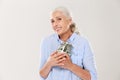 Happy smiling mature woman hugging her glass jar with dollars Royalty Free Stock Photo