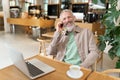 Happy mature business man sitting in cafe talking on phone making call. Royalty Free Stock Photo