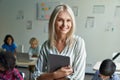 Happy smiling middle aged woman school teacher posing in classroom. Royalty Free Stock Photo