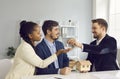 Happy smiling millennial multiethnic couple taking key from realtor agent Royalty Free Stock Photo