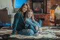 Smiling mother with her daughter in the room on the carpet