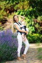 Happy smiling mother with baby boy in sling walking in park Royalty Free Stock Photo