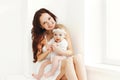 Happy smiling mother with baby at home in white room Royalty Free Stock Photo