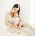 Happy smiling mother with baby at home in white room Royalty Free Stock Photo