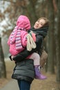 Happy smiling mother with a child daughter in her arms posing at spring park path outdoors Royalty Free Stock Photo