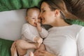 Happy smiling mother and child lying on the bed at home on the bed, top view. mother kisses her son Royalty Free Stock Photo