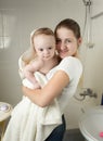 Portrait of happy smiling mother covering her baby boy after washing in shower Royalty Free Stock Photo