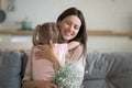 Happy smiling mother embracing little daughter, thanking for gift