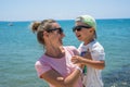 Happy smiling mother and her son playing and running on the beach. Concept of friendly family Royalty Free Stock Photo