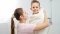 Happy smiling mother hugging and covering her son in bath towel after taking shower. Concept of hygine, children