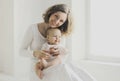 Happy smiling mother and little baby together in white room at home Royalty Free Stock Photo