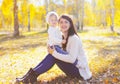 Happy smiling mother with little child playing in sunny autumn Royalty Free Stock Photo