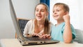 Happy smiling mother with little son using laptop and looking on computer screen. Royalty Free Stock Photo