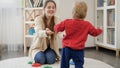 Happy smiling mother looking and helping her little baby boy making his first steps. Baby development, child playing games, Royalty Free Stock Photo