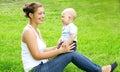 Happy smiling mother and son child sitting on the grass Royalty Free Stock Photo