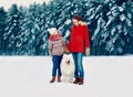 Happy smiling mother and son child walking together with white Samoyed dog in snowy winter day Royalty Free Stock Photo