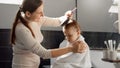 Happy smiling mother wiping her baby son in bath with towel and combing his hair. Concept of parenting, happiness and child Royalty Free Stock Photo