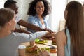 Happy smiling multiracial friends joining hands at meeting in cafe Royalty Free Stock Photo