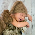 Happy smiling newborn baby boy in knitted hat and pants, soundly sleeping Royalty Free Stock Photo