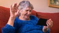 Happy smiling old woman fallen hand in greeting while using a smartphone Royalty Free Stock Photo