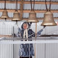 Happy smiling older woman playing the bells in winter day