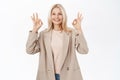 Happy smiling older woman, 50 years old, mature female model, shows okay, ok sign in approval, recommending smth Royalty Free Stock Photo