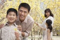Happy, smiling parents with two children enjoying the park in springtime and looking at flowers Royalty Free Stock Photo