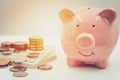 Happy smiling piggy bank with pile of coin money for personal income saving money and financial concept