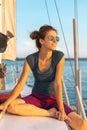 Happy smiling portrait of a beautiful young girl in sunglasses on a yacht or boat on the coast with the sea in the background Royalty Free Stock Photo