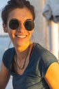 Happy smiling portrait of a beautiful young girl in sunglasses on a yacht or boat on the coast with the sea in the background Royalty Free Stock Photo