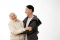 Happy smiling positive pencioner couple in hoodies hugging, stylish old man and woman isolated over white background Royalty Free Stock Photo