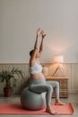 Happy smiling pregnant woman doing exercises sit on fitness ball in living room. Royalty Free Stock Photo