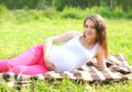 Happy smiling pregnant woman resting lying on grass in summer Royalty Free Stock Photo