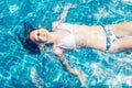 Happy smiling preteen girl in bikini enjoys swimming in the pool. Childhood, vacation, travel concept