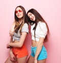 Happy smiling pretty teenage girls or friends hugging over pink Royalty Free Stock Photo