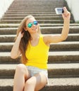 Happy smiling pretty young woman makes self-portrait on smartphone in city Royalty Free Stock Photo