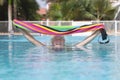 Happy smiling relaxed senior people in the swimming pool with a colorful towel in the hands - active elderly retired man during Royalty Free Stock Photo