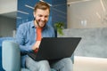 happy smiling remote online working man in casual outfit with laptop in joyful successful winning gesture sitting in an