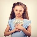 Happy smiling rich kid girl holding money and presseing to the c Royalty Free Stock Photo