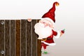 Happy smiling Santa Claus standing behind a blank sign, showing a large wooden sign.Christmas card