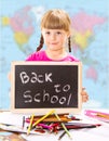Happy smiling schoolchild holding small blackboard